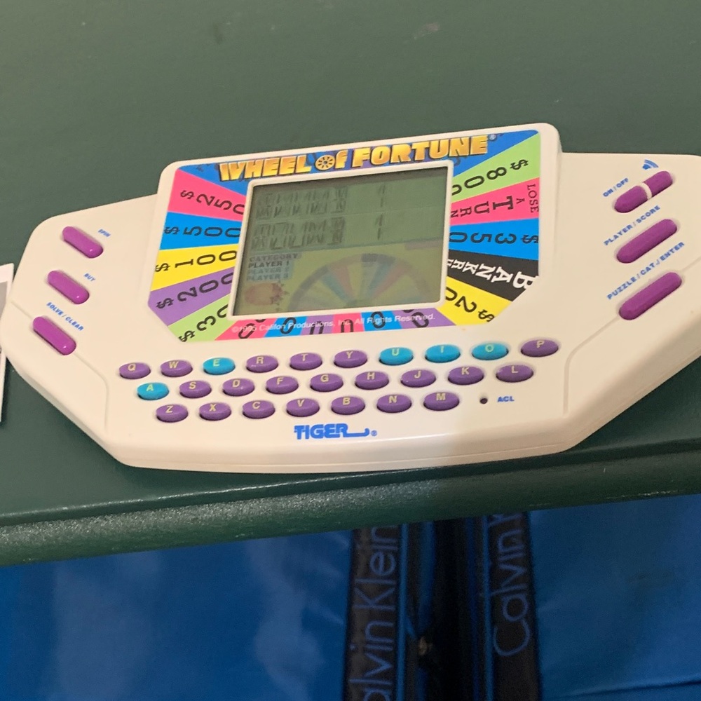 Tiger Electronics Handheld Wheel of Fortune Game - White and Purple